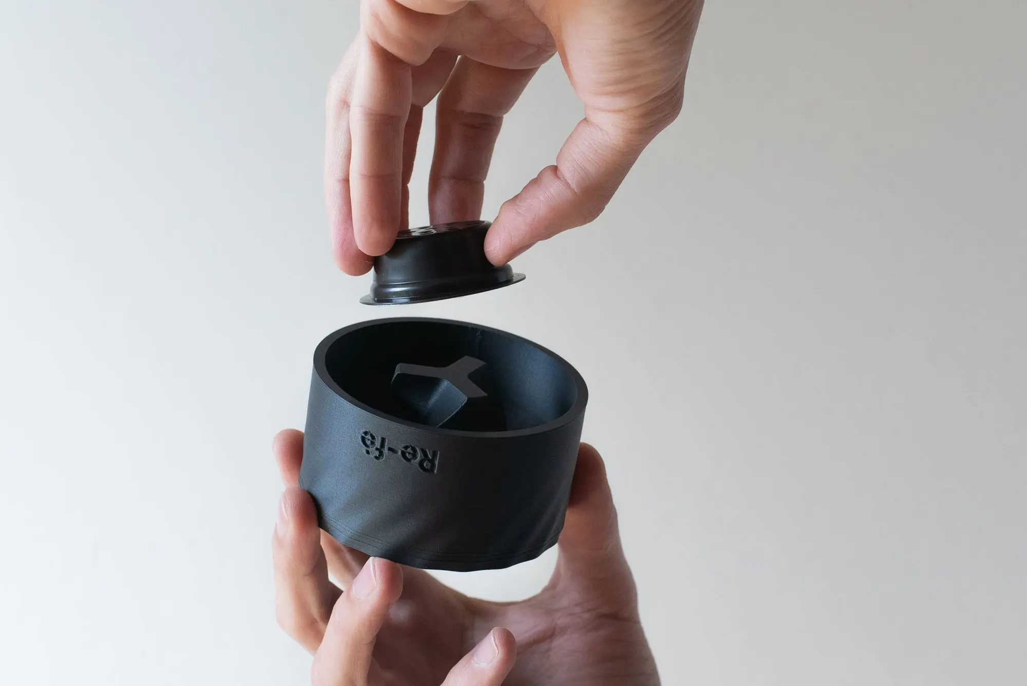Re-fè TWIST tenuto in mano con una capsula sopra